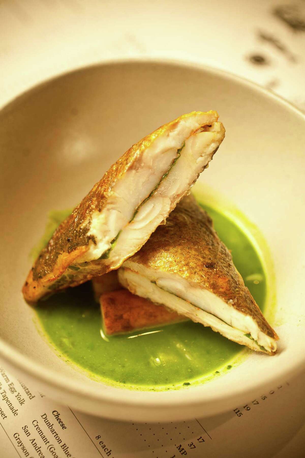 The Pass & Provisions' branzino fillets sandwiching lovage on a mussel/parsley/ginger soup with marrow browned potatoes, Tuesday, Sept. 11, 2012, in Houston. ( Nick de la Torre / Houston Chronicle )