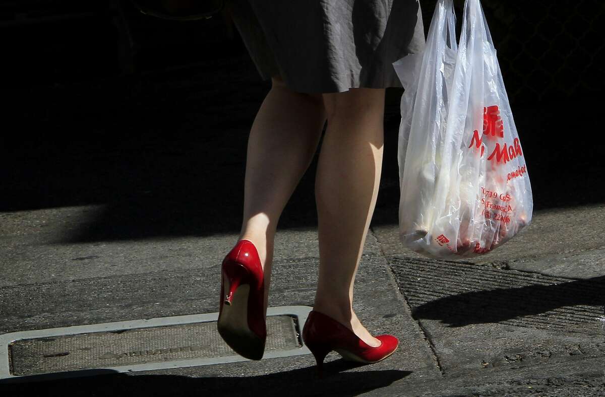 A woman carries a plastic bag in Chinatown in San Francisco, Calif., Monday, October 1, 2012. San Francisco's city-wide plastic bag ban went into effect Monday, and now people will be charged ten cents for paper bags.