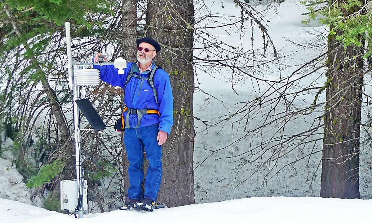 Steven Glaser adjusting the solar radiation sensor at a wireless sensor network station. Visible is the snow depth sensor at the end of the cross-ark and the housing for the temperature - relative humidity sensor. The radio and electronics are in the box bolted to the pole.