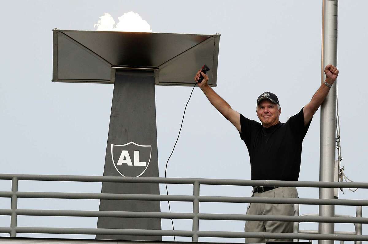 Former Oakland Raiders quarterback Daryle Lamonica raises his arms after lighting a torch for former owner Al Davis before an NFL preseason football game between the Oakland Raiders and the Dallas Cowboys in Oakland, Calif., Friday, Aug. 9, 2013. (AP Photo/Marcio Jose Sanchez)