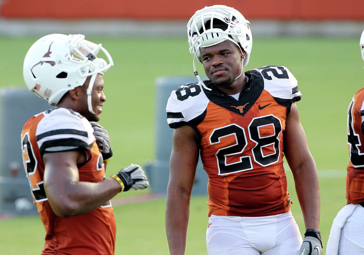 Malcolm Brown listens to Johnathan Gray during a break at UT football practice at Denius Fields in Austin on August 9, 2013.