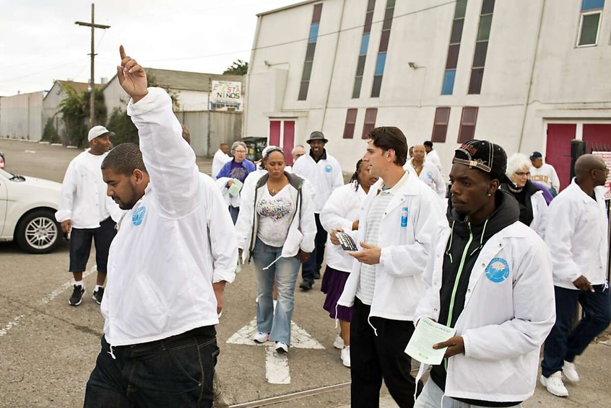 Justin Sexton, of At Thy Word ministry, acts as a group leader for a CeaseFire walk with others to pray, talk with residents about violence and gun buyback programs in East Oakland, Calif., Friday, August 9, 2013.