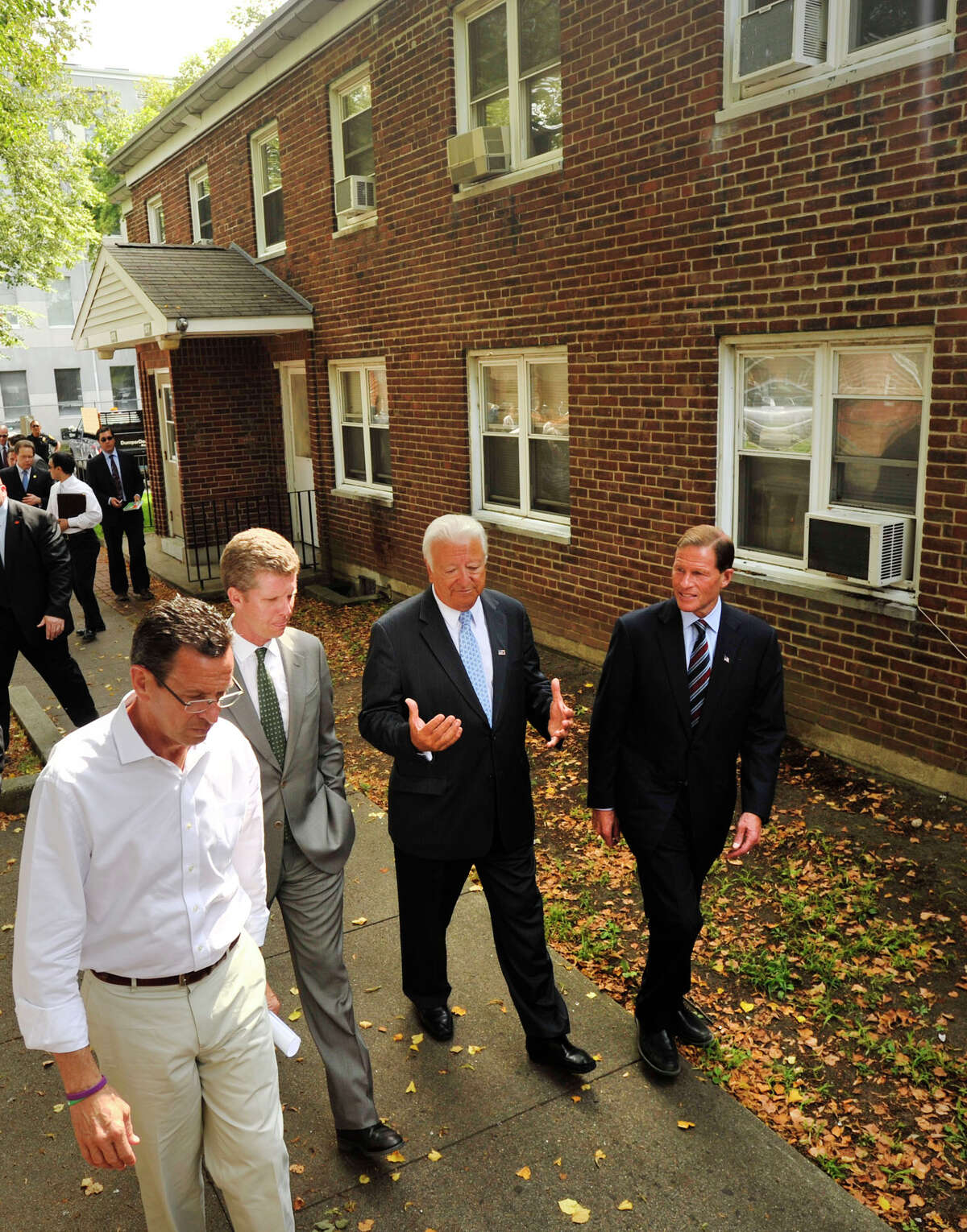 From left, Gov. Dannel P. Malloy, Secretary of Housing and Urban Development Shaun Donovan, Norwalk Mayor Richard Moccia and Sen. Richard Blumenthal tour the Washington Village housing project in Norwalk, Conn., on Monday, Aug 12, 2013. First floor residents from Washington Village received flooding due to the storm surge from storm Sandy. Government officials are proposing to demolish the current dwellings and replace them with a housing project that is elevated above the flood level.