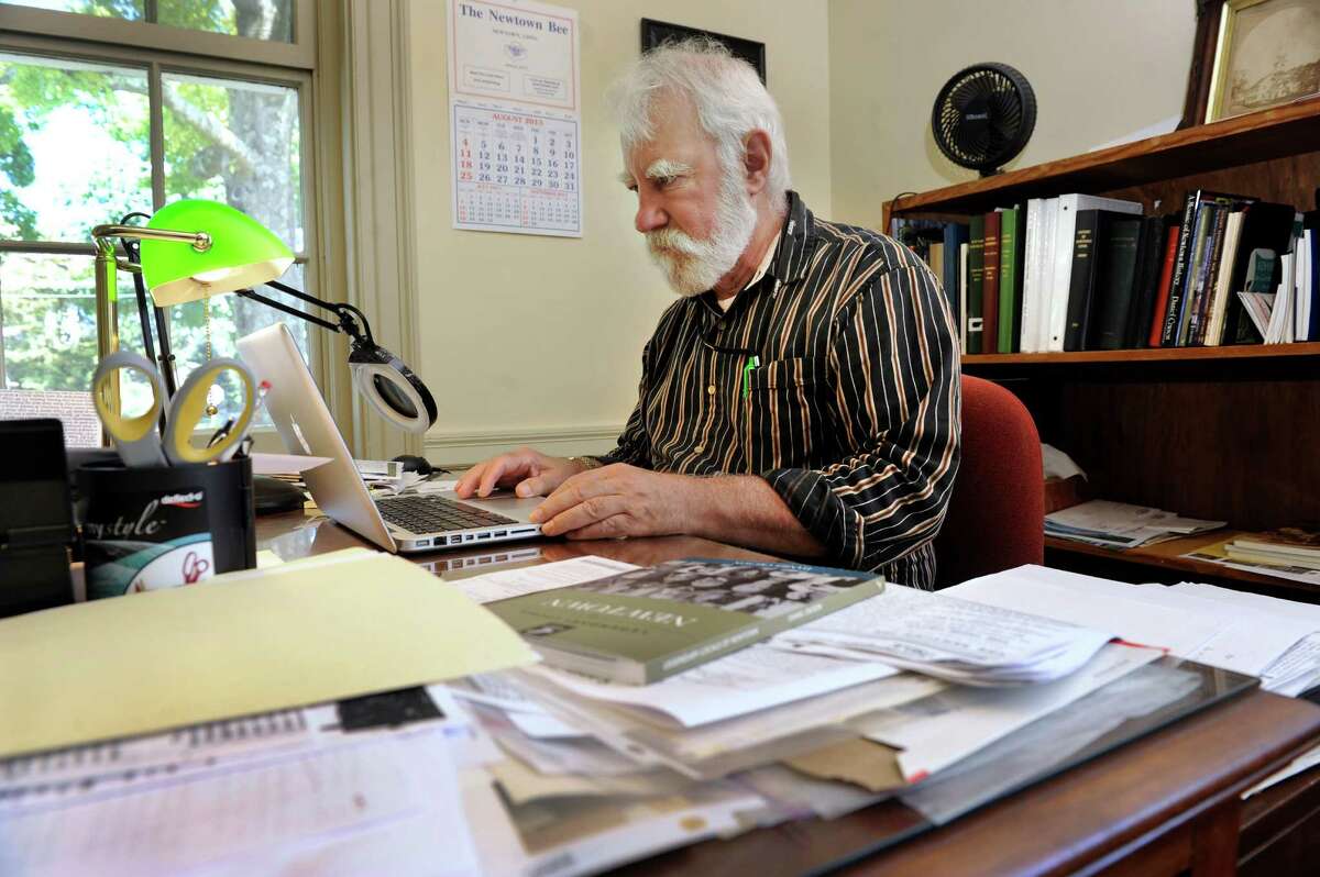Town Historian Dan Cruson, 68, has written a book about the people of Newtown, including a special tribute to those lost in the shooting tragedy at Sandy Hook. He is photographed in his office at the Edmond Town Hall, in Newtown, Conn., Monday, Aug. 5, 2013.