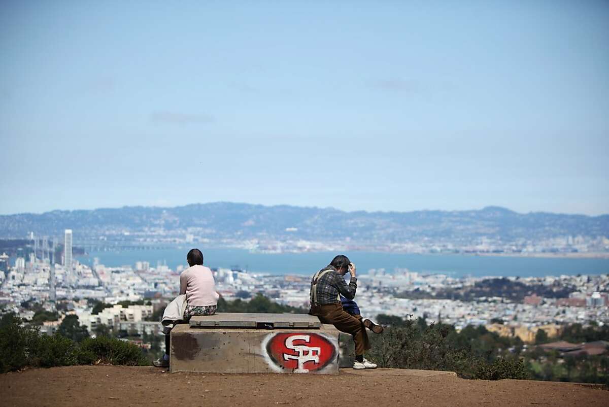 2013年8月8日，加利福尼亚州旧金山，帕特里夏·伍德(左)和比尔·帕斯奎内利静静地坐在戴维森山顶附近一个装饰着49人队标志的混凝土舱口上。