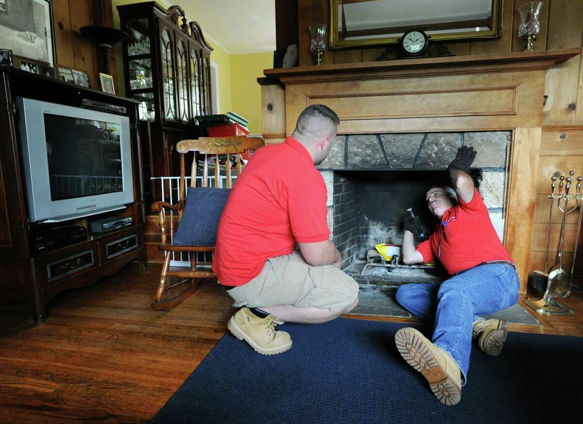 G. Neil Scott, right, and his son, Neil Scott, inspect the fireplace at a McArthur Lane home in Stamford, Tuesday, August 13, 2013. G. Neil Scott is the owner of Scott and Scott Home Inspection Services Inc., of Stamford.