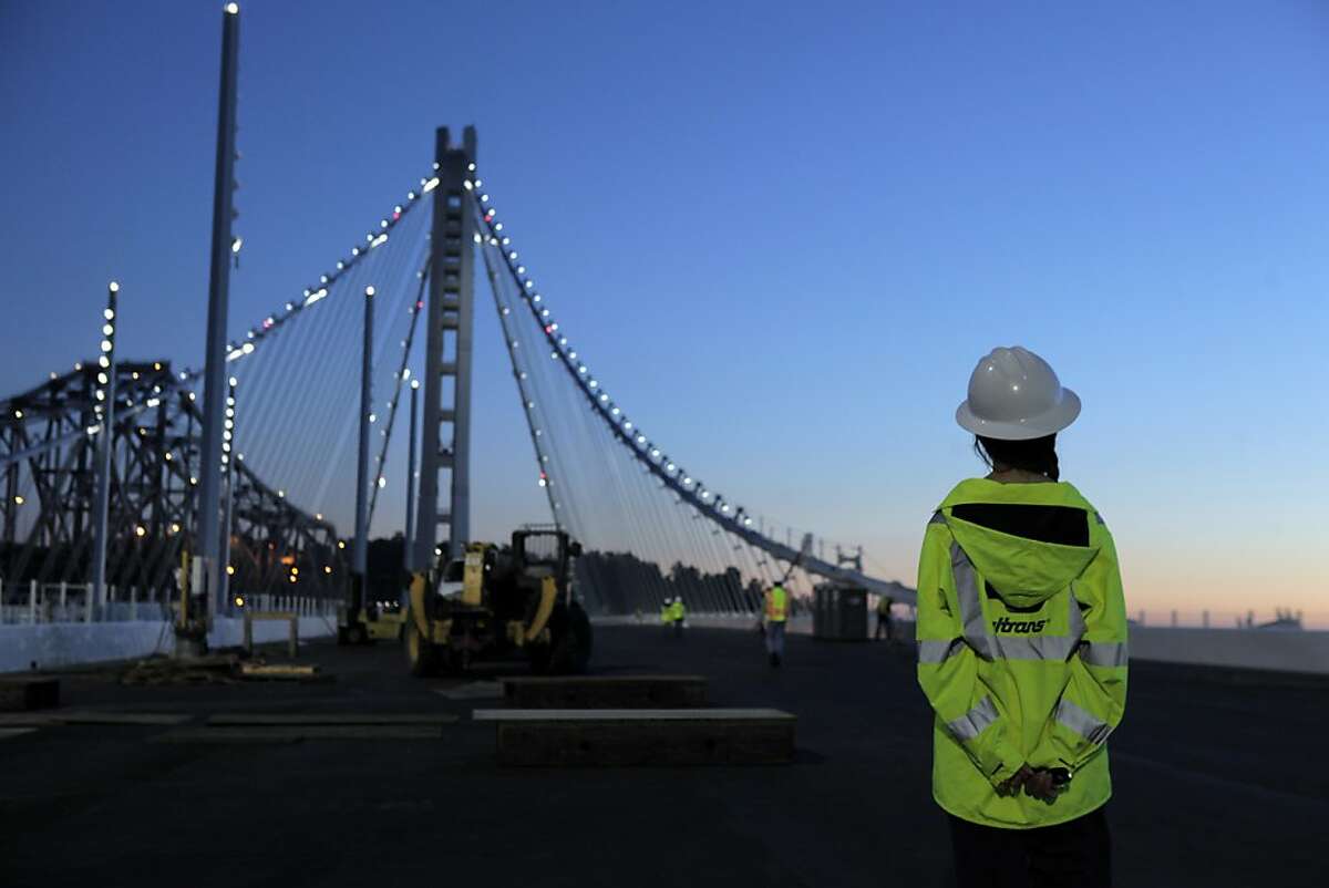 Chelsea Wurms with MTC looks at the tower of the new section of the San Francisco-Oakland Bay Bridge after it was lighted on Tuesday, August 11, 2013, as members of the MTC, Caltrans and the press took a walking tour of the new structure in San Francisco, Calif.