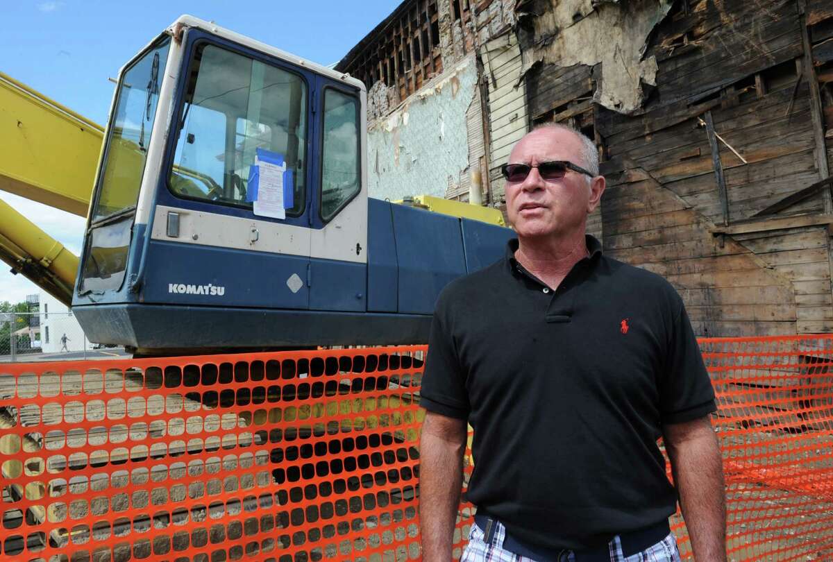 Troy city councilman Mark McGrath talks about the demolition process Wednesday, Aug. 14, 2013, which took place on King St. in Troy, N.Y., where buildings 4, 6, 8 and 10 were torn down. The state labor department issued a stop-work order at the site over asbestos concerns. A cease and desist notice is taped to construction equipment in the background. (Lori Van Buren / Times Union)