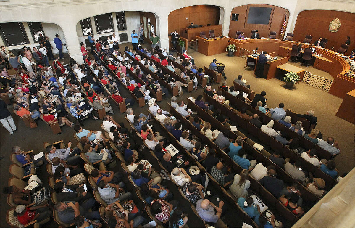 ABOVE: People pack the City Council chambers to voice their opinions regarding the proposed anti-discrimination policy change. LEFT: Residents opposed to the policy change gather on the steps of City Hall for a prayer vigil prior to appearing before the council.