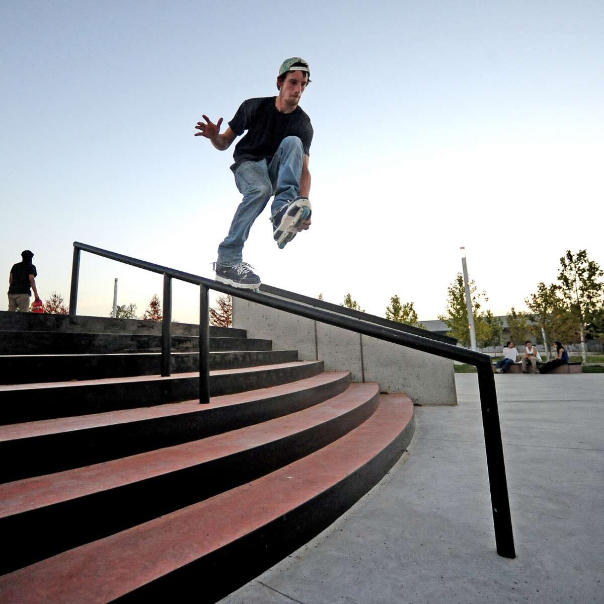 Local comedian Jack Neil lands a grabbed makio down the handrail at the Beautiful Mountain Skate Plaza on Tuesday, August 6, 2013. Photo taken: Randy Edwards/The Enterprise