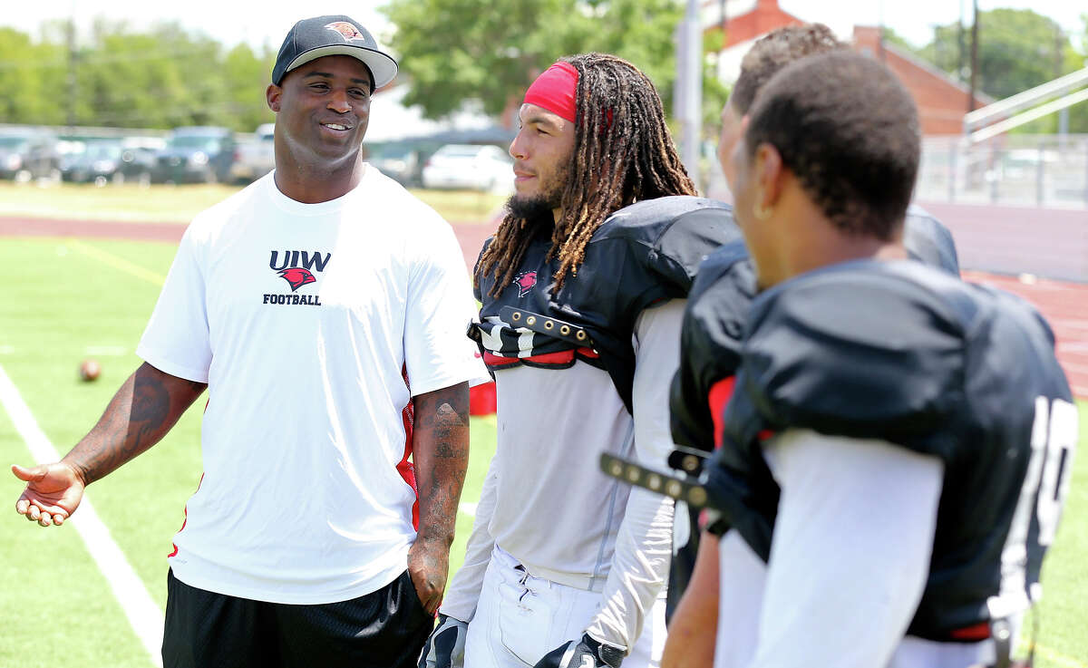 University of the Incarnate Word new assistant football coach Ricky Williams (left) talks with player Devin Haywood and others during practice held Thursday Aug. 15, 2013 at the university.
