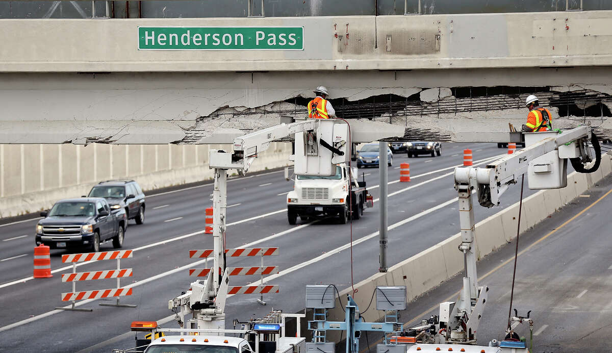 Workers repair the Henderson Pass bridge at U.S. 281 after a southbound 18-wheeler slammed into the overpass Wednesday afternoon. The southbound lanes on 281 headed toward downtown are closed at Henderson Pass and the northbound exit ramp onto Loop 1604 from 281 also is shut.
