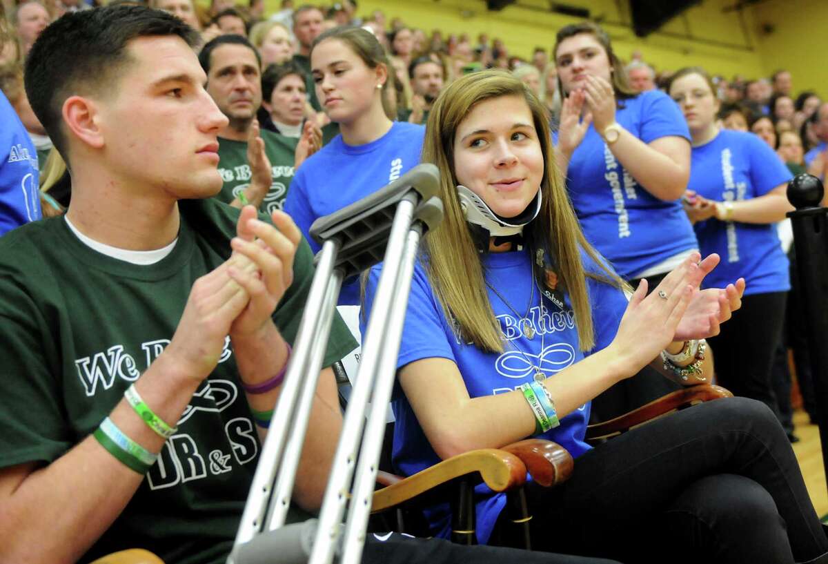 Bailey Wind, 17, center, and Matt Hardy, 17, applaud at introductions during a ceremony on Thursday, Jan. 10, 2013, at Siena College in Loudenville, N.Y. Shaker and Shenendehowa girls and boys basketball teams played games to benefit the memorial scholarship funds for Chris Stewart and Deanna Rivers, Shenendehowa athletes who were both killed in a recent car crash. (Cindy Schultz / Times Union)