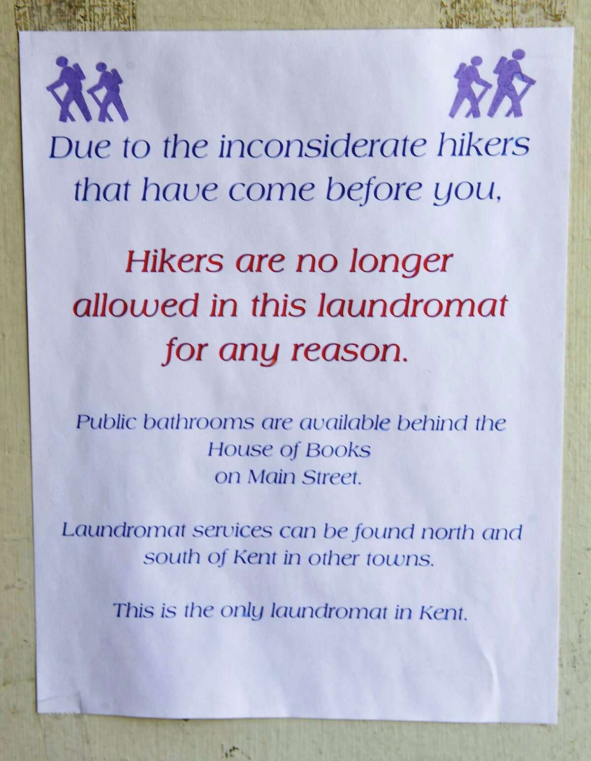 This sign is posted on the front door of the Kent Green Laundromat in Kent, Conn. Friday, Aug. 16, 2013.