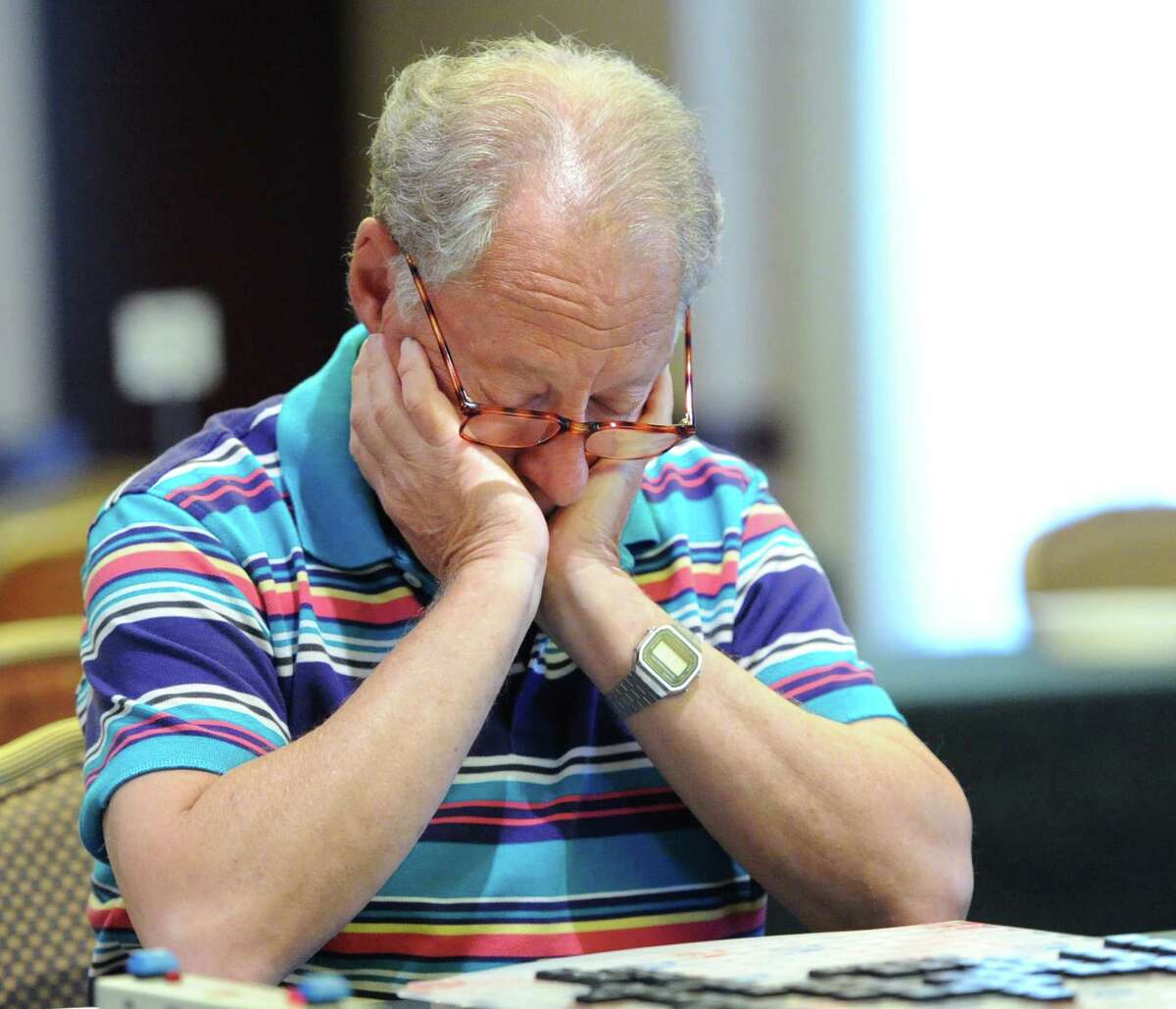 Jack Eichenbaum of Flushing, Queens, New York City, with eyes pointed straight down, looks as if he is sleeping but instead he is studying the board while playing a Scrabble match during the third annual Old Greenwich Scrabble Tournament at the Hyatt Regency Greenwich, Friday, August 16, 2013.