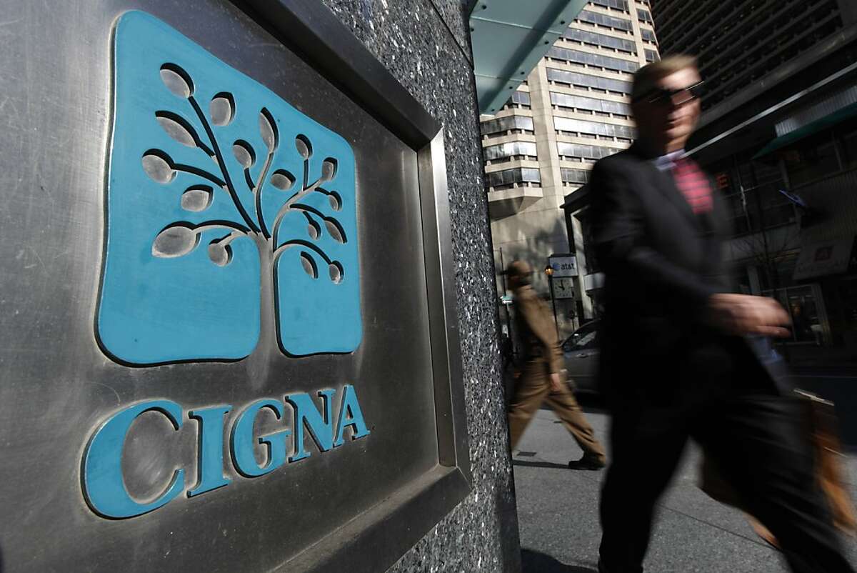 FILE - In this Nov. 17, 2009 file photo, a pedestrian walks past the headquarters of the health insurer Cigna Corp. in in Philadelphia. Managed care company Cigna said Friday, Oct. 29, 2010, its third-quarter profit fell 6.7 percent on higher medical costs and losses from the company's reinsurance segment.