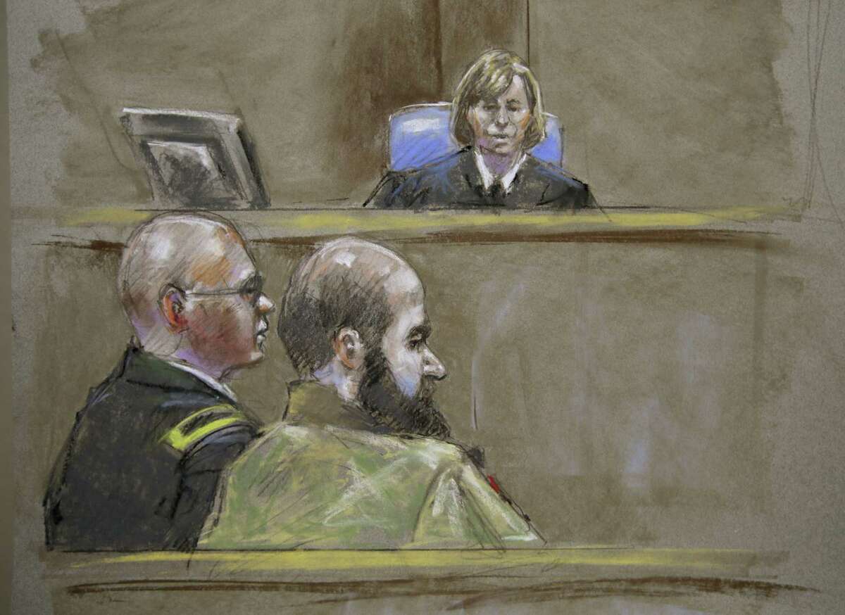 This courtroom sketch portrays Maj. Nidal Hasan (foreground) and attorney Lt. Col. Kris Poppe in front of the judge, Col. Tara Osborn.
