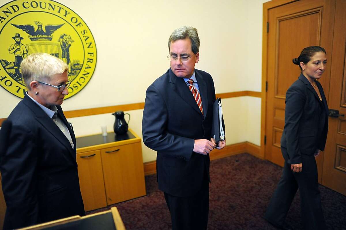 Flanked by Chief Deputy City Attorney Theresa Stewart, left and Sara Eisenberg, right, City Attorney Dennis Herrera leaves the room after reporting during a press conference at City Hall that he has filed dual legal challenges to the possible termination of City College of San Francisco's accreditation, in San Francisco, California on Thursday, August 22, 2013.