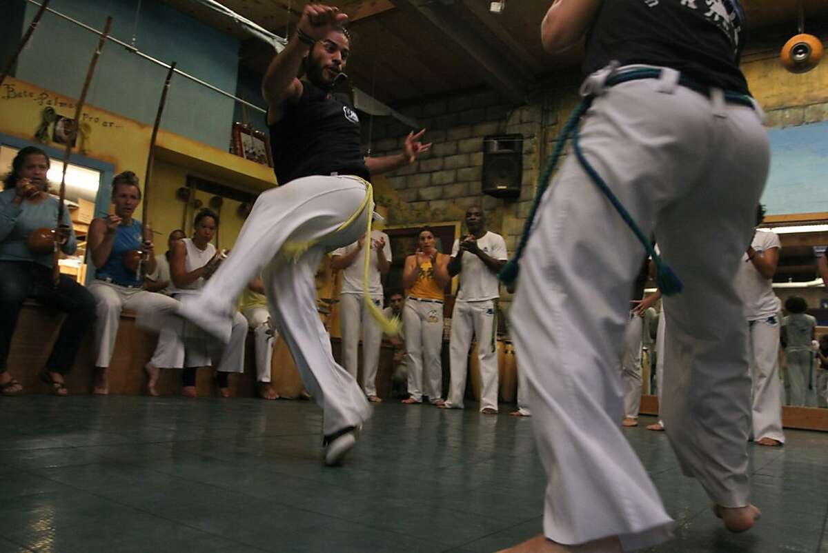 Diego "Tarantula" Arana, left, who will ride with Mestre Acordeon and others from Berkeley to Brazil, trains at Capoeira Arts Foundation in Berkeley, Calif. on Wednesday, August 21, 2013.