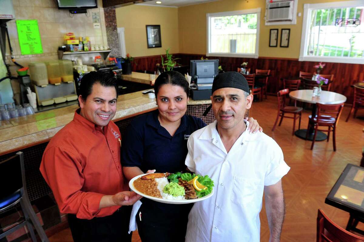Elmer Palma, left, stands with Josselin Garcia and Rudy Garcia in his new restaurant, Chaparro's Latin Family Restaurant, in Danbury, Conn. Thursday, Aug. 15, 2013. They are holding a plate of New York Steak a la Mexicana.