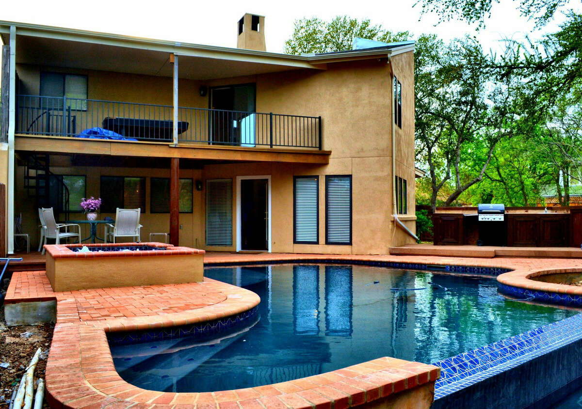 A patio and balcony overlook the pool and spa at one of the North Side houses QF Properties rents to vacationers.