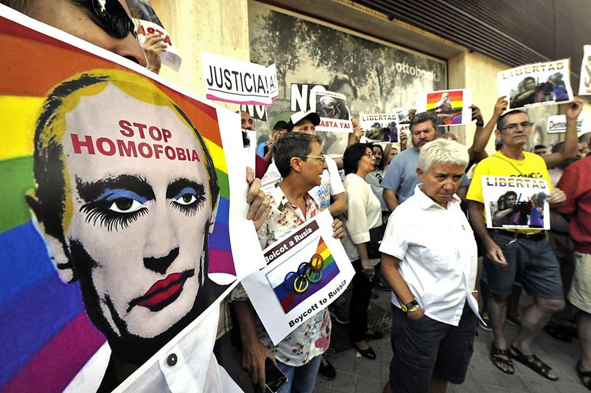 Demonstrators holds placards and posters depicting Russian President Vladimir Putin with make-up as they protest against homophobia and repression against gays in Russia, in front of the Russian Embassy in Madrid on August 23, 2013. AFP PHOTO/ GERARD JULIENGERARD JULIEN/AFP/Getty Images