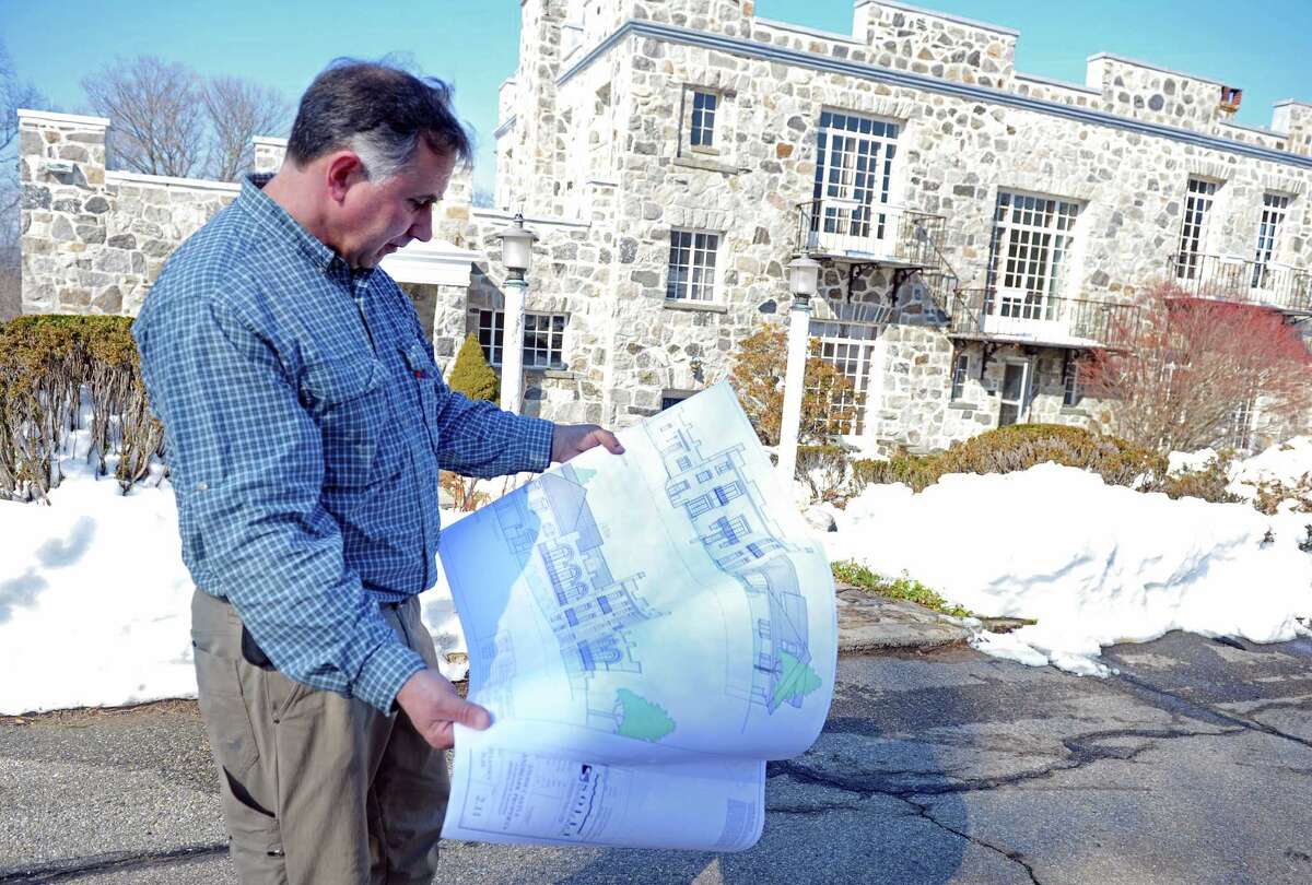 John Kimball, CEO of The Kimball Group, looks over blueprints for The Stone Castle on the Sisters of the Holy Family of Nazareth property at 1428 Monroe Turnpike in Monroe, Conn. last February.