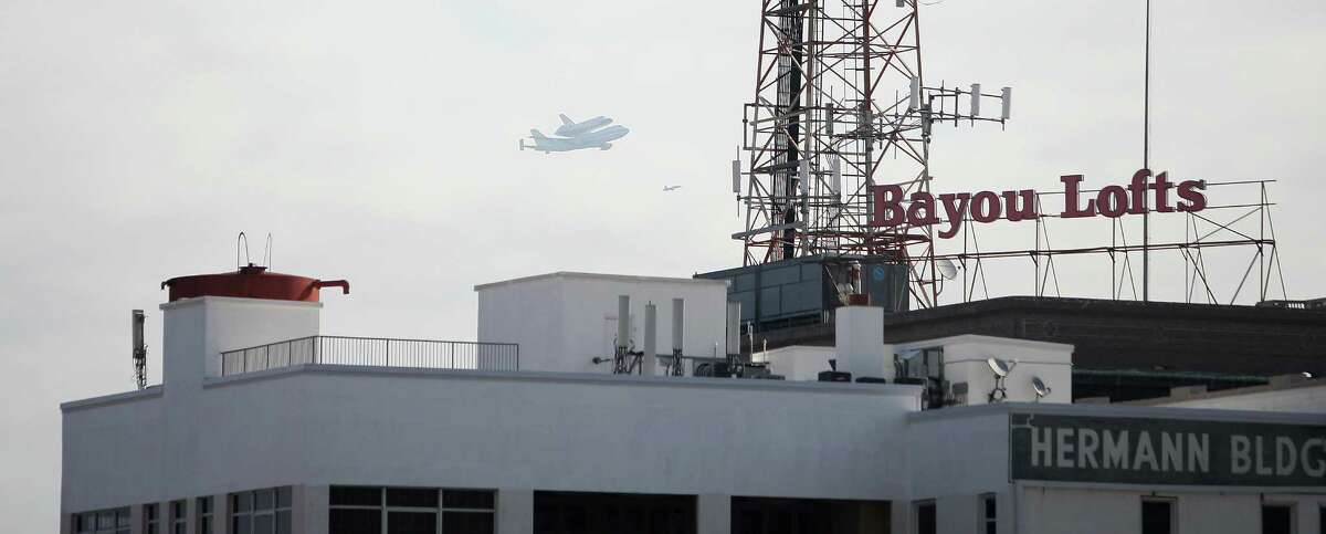The space shuttle Endeavour flies over Bayou Lofts in 2012. The downtown building has 106 condo units. ﻿