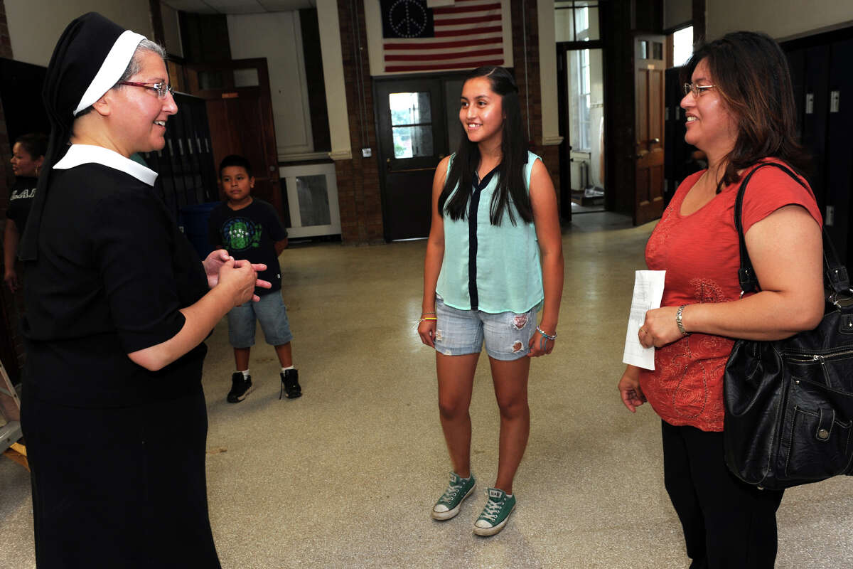 Teacher Sister Lisa Florio welcomes 8th grader Mayra Vargas and her mother Sara Pineda to the new Cathedral Academy Intermediate & Middle School Campus during an open house in Bridgeport, Conn., Aug. 26, 2013.