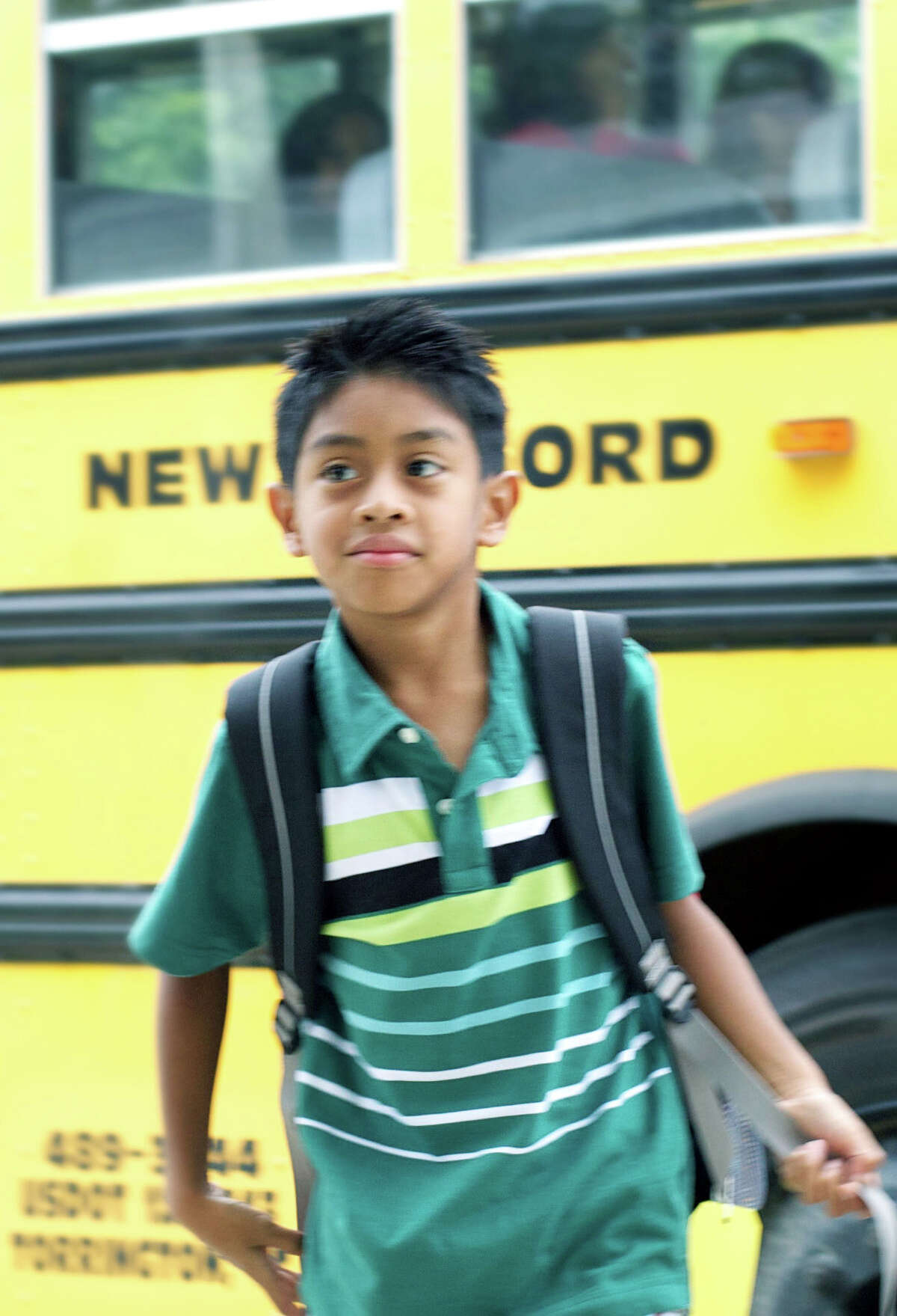 Second-grader Matty Napoli strides from his school bus with confidence as he and his fellow John Pettibone School School students start the 2013-14 school year in New Milford.