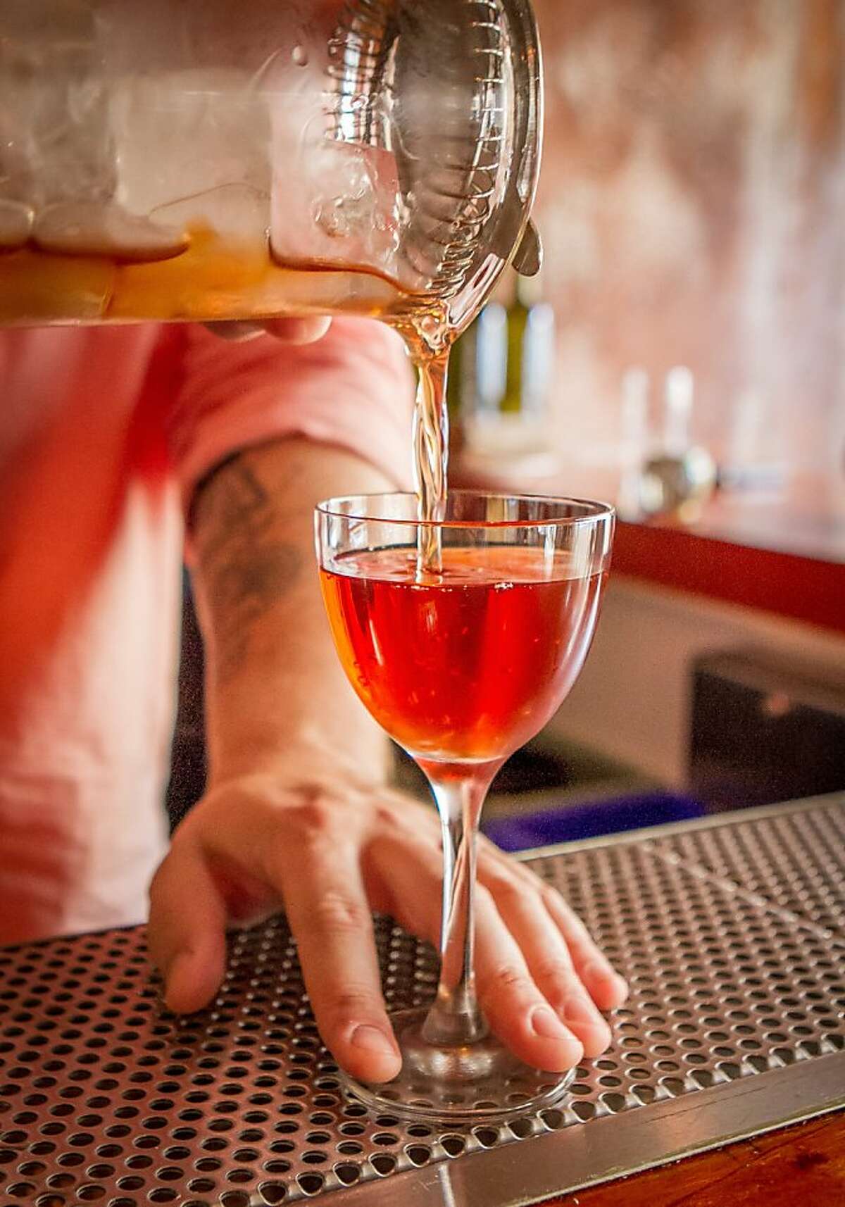 2013年8月24日，加州奥克兰Duende酒吧，调酒师Yannick Gabadov正在为顾客倒一杯经典的曼哈顿鸡尾酒。