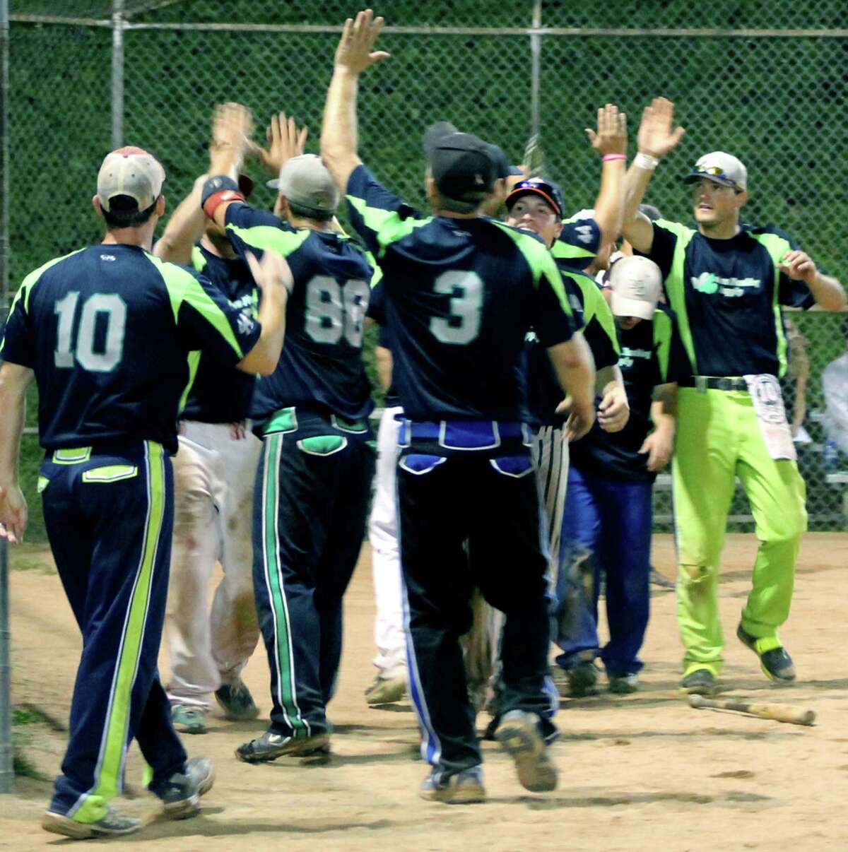 The Modern Plumbing men's softball team did plenty of celebrating during its perfect 2013 New Milford Parks & Recreation's 'A' division season. Above, plumbers including Rob Colburn (3), Steve Schaab (10) and Brett Thompson (88) welcome Ronnie Newkirk, amidst his teammates, following his three-run homer during Modern's 11-4 playoff title clincher at Young's Field. August 2013 Courtesy of Kennie Olson
