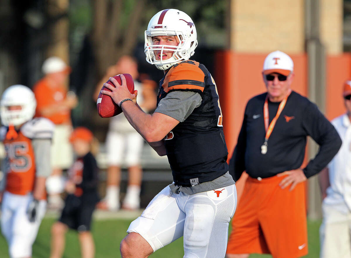 David Ash throws passes under watch by Mack Brown during UT football practice at Denius Fields in Austin on August 9, 2013.