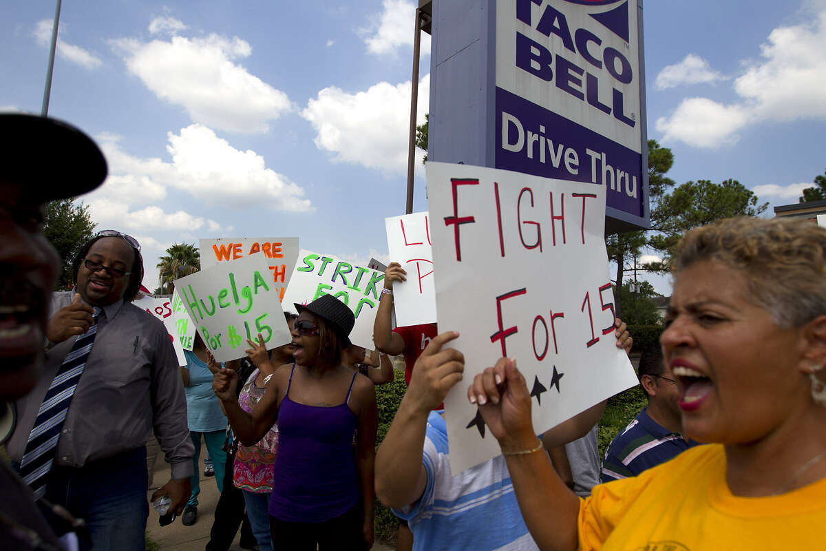 Protesters rally in front of Taco Bell in Houston to protest wages paid to fast food employees. Protesters joined a national movement to try to get an increase in minimum wage to $15 per hour for fast food employees.