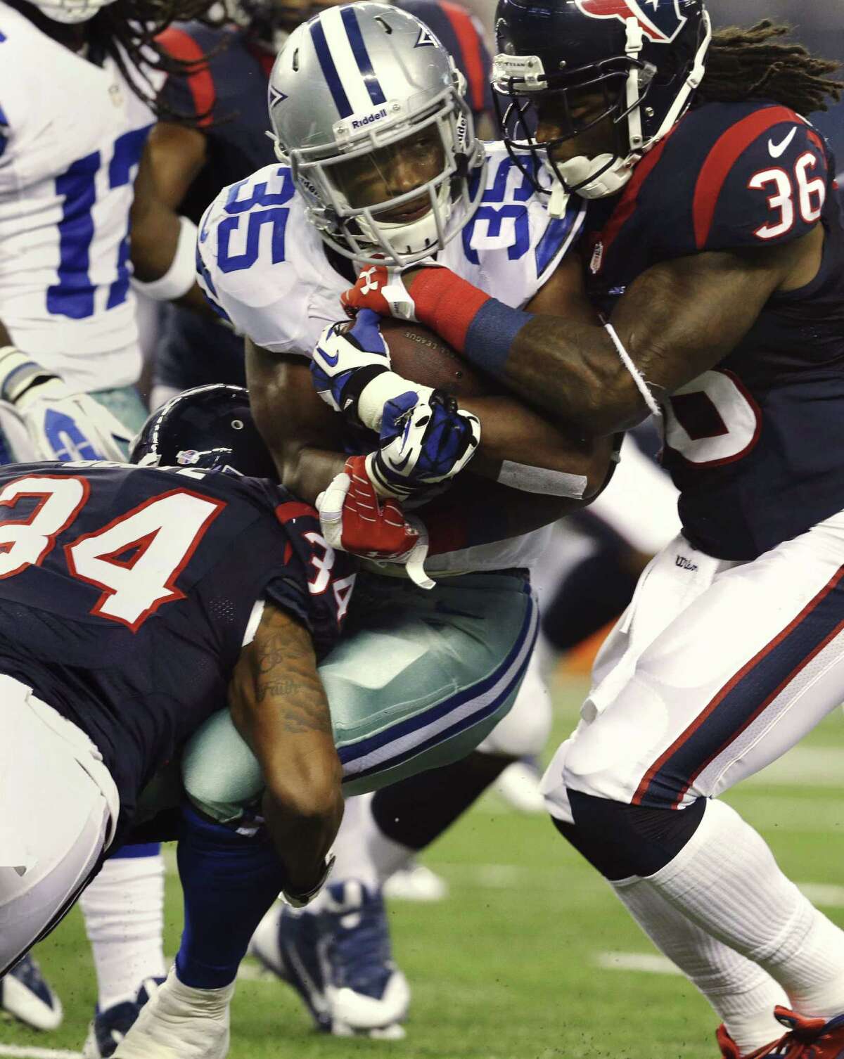 Cowboys running back Joseph Randle is swarmed by Texans A.J. Bouye (left) and D.J. Swearinger in the first half.