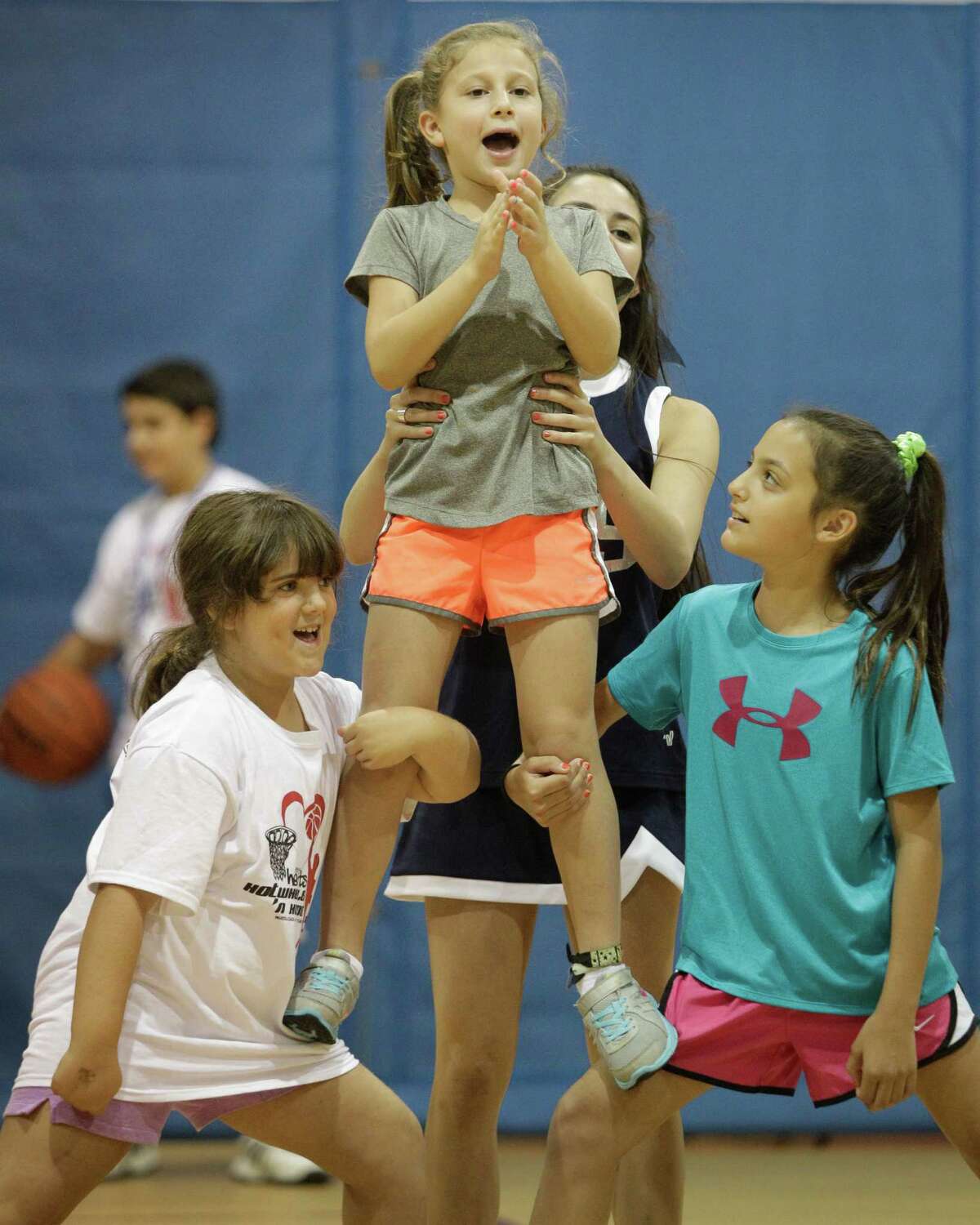 Willa Berry, center, leads a cheer as she is supported by Molly Horowitz, 16, Sara Rozen, 7, left, and Maya Levy, 10, right, during the tournament.