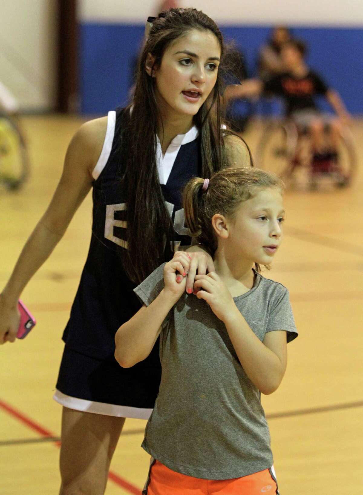 Willa Berry holds onto Molly Horowitz, 16, a junior at Emery/Weiner High School during a wheelchair basketball fundraiser at The Zone, 10371 Stella Link, Sunday, Aug. 25, 2013, in Houston. Willa and her two brothers, Peter and Aaron, survived a car accident that killed their father and mother, Josh and Robin Berry, on July 2, 2011, in West Texas while on their way back from a family vacation in Colorado. Peter and Aaron were left paralyzed. ( Melissa Phillip / Houston Chronicle )