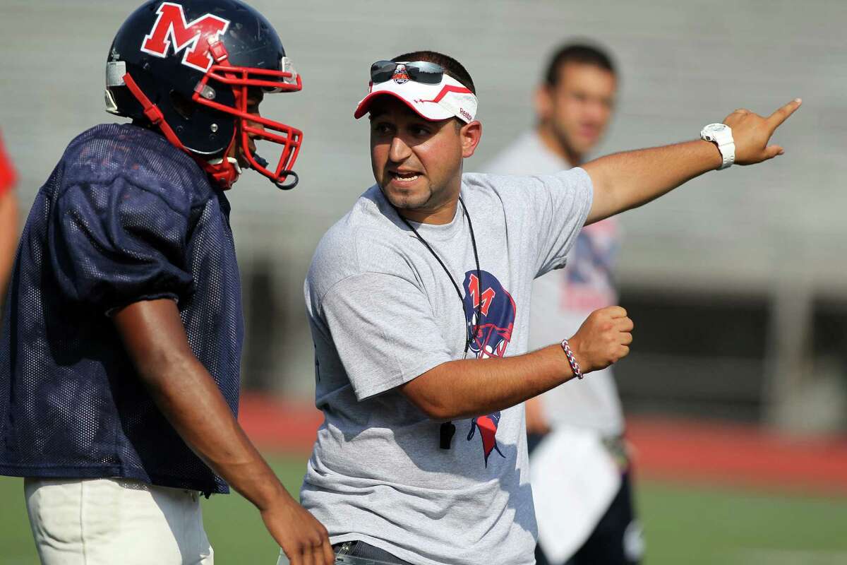 Brien McMahon head coach A.J. Albano goes over defensive postioning with one of his players during football practice on Friday Aug.30, 2013 in Norwalk, Conn.