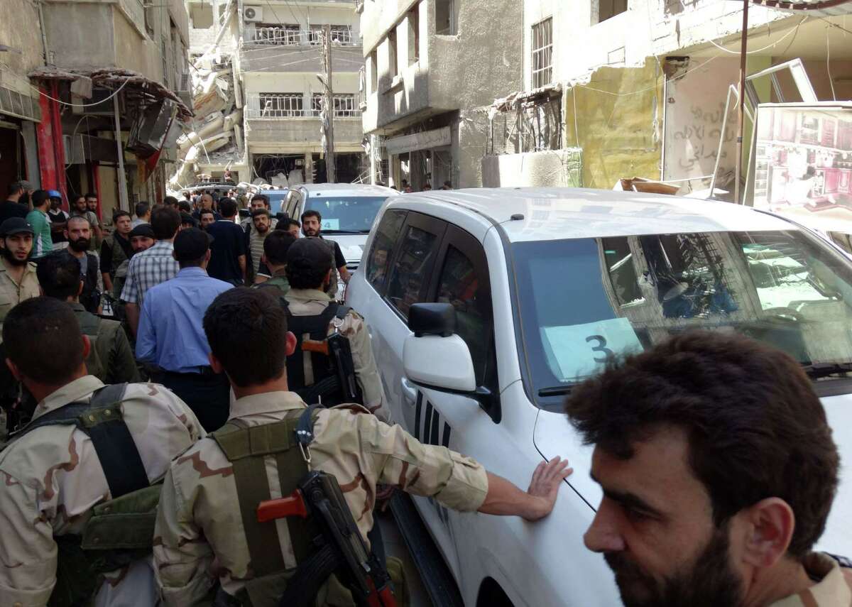 Syrian rebel fighters and civilians surrounded the U.N. arms experts as they arrived last week to inspect a possible chemical attack site outside Damascus.