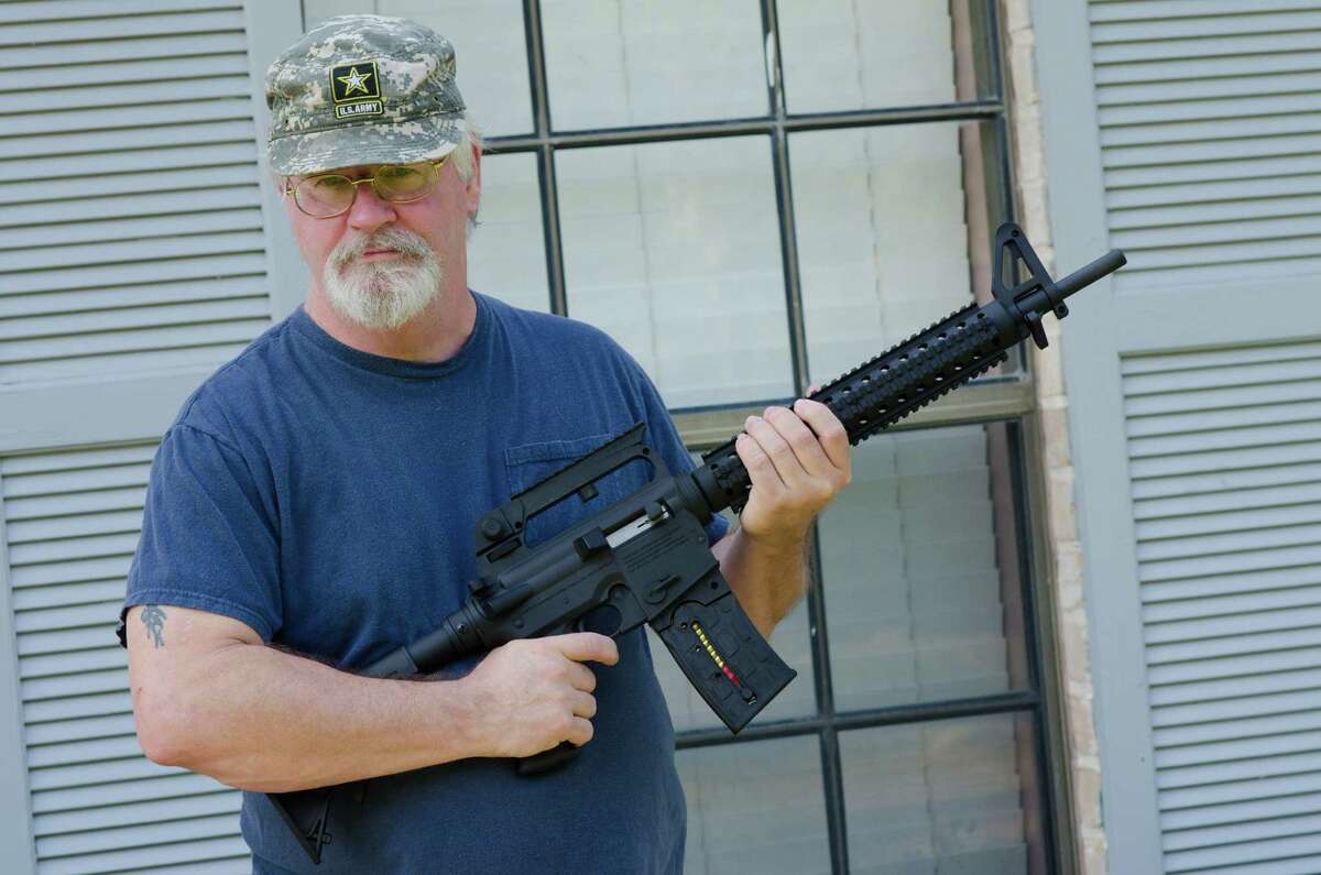 Army retiree Ron Kelly holds his new Mossberg .22-caliber rifle at his Tomball home on Friday. Kelly originally had been denied permission to buy a rifle because of a 1971 marijuana possession conviction.