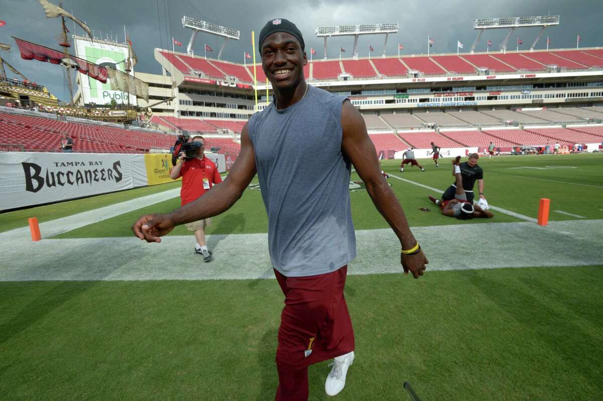 Washington Redskins quarterback Robert Griffin III leaves the field after warming up before a preseason NFL football game against the Tampa Bay Buccaneers in Tampa, Fla., Thursday, Aug. 29, 2013.(AP Photo/Phelan M. Ebenhack)