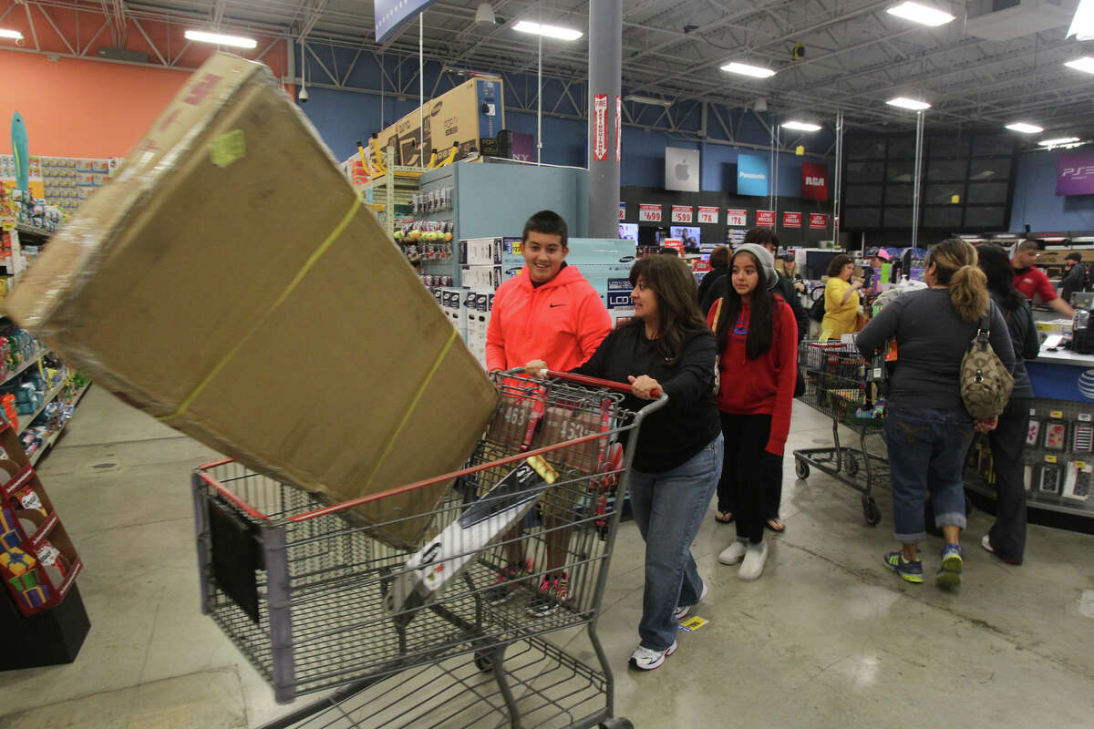 Shopper Eva Avalos pushes a shopping cart out of the electronics area of the H-E-B plus! store at Blanco and Loop 1604 Black Friday November 23, 2012.