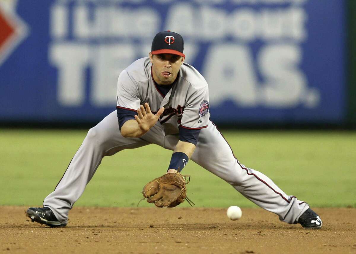 The Twins' Brian Dozier fields a double-play ball hit by the Rangers' Elvis Andrus in the third inning.