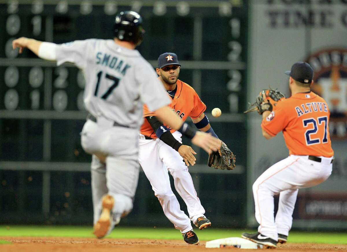 Astros shortstop Jonathan Villar, center, makes the toss to second baseman Jose Altuve, right, to force Seattle's Justin Smoak on Henry Blanco's fielder's-choice grounder in the second inning Friday night.