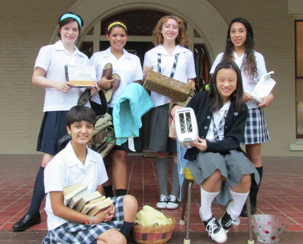Providence Catholic School students show some acceptable items for theirSept. 15 Goodwill drive. Standing, left to right, are Tess Acosta, Natalie Beauchamp, Anna Tabet and Samantha Watson. Seated are Liz Gomez and Aina Ongcheap.