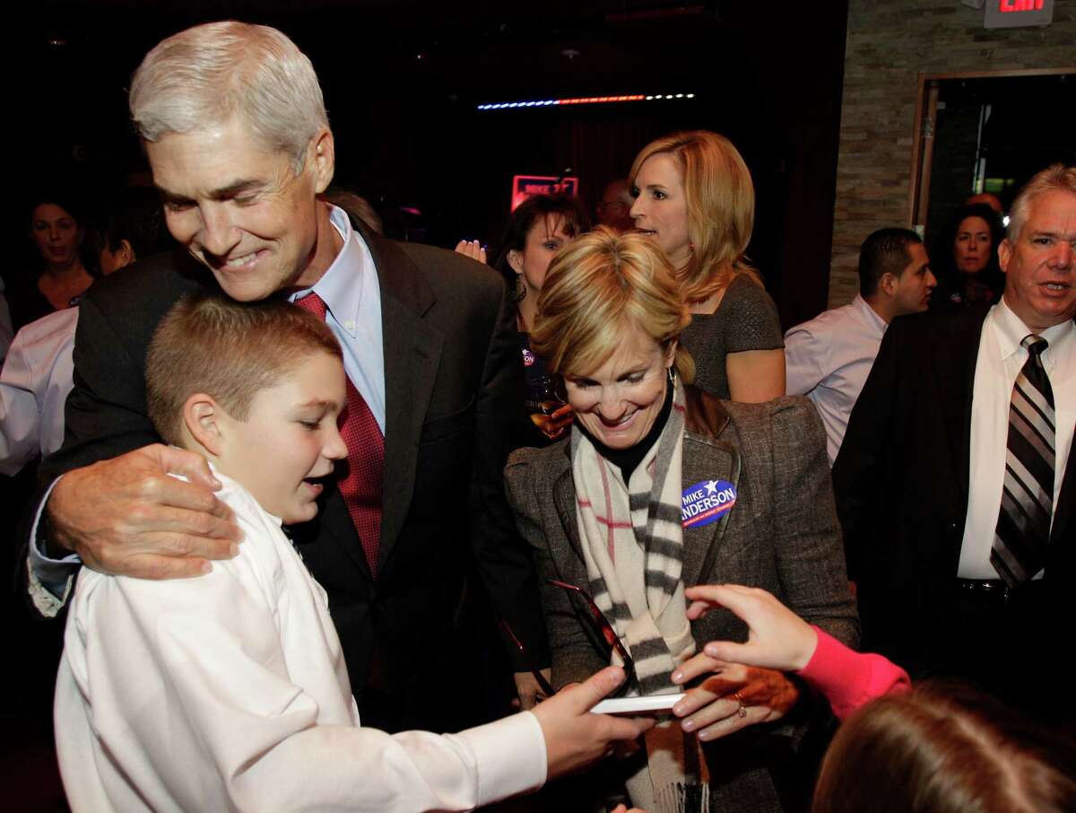 In a celebratory scene on Nov. 6, 2012, Mike Anderson hugs his son, Sam, as his sister, Jan Bailey, right, and wife, Devon Anderson, back right, greet supporters.