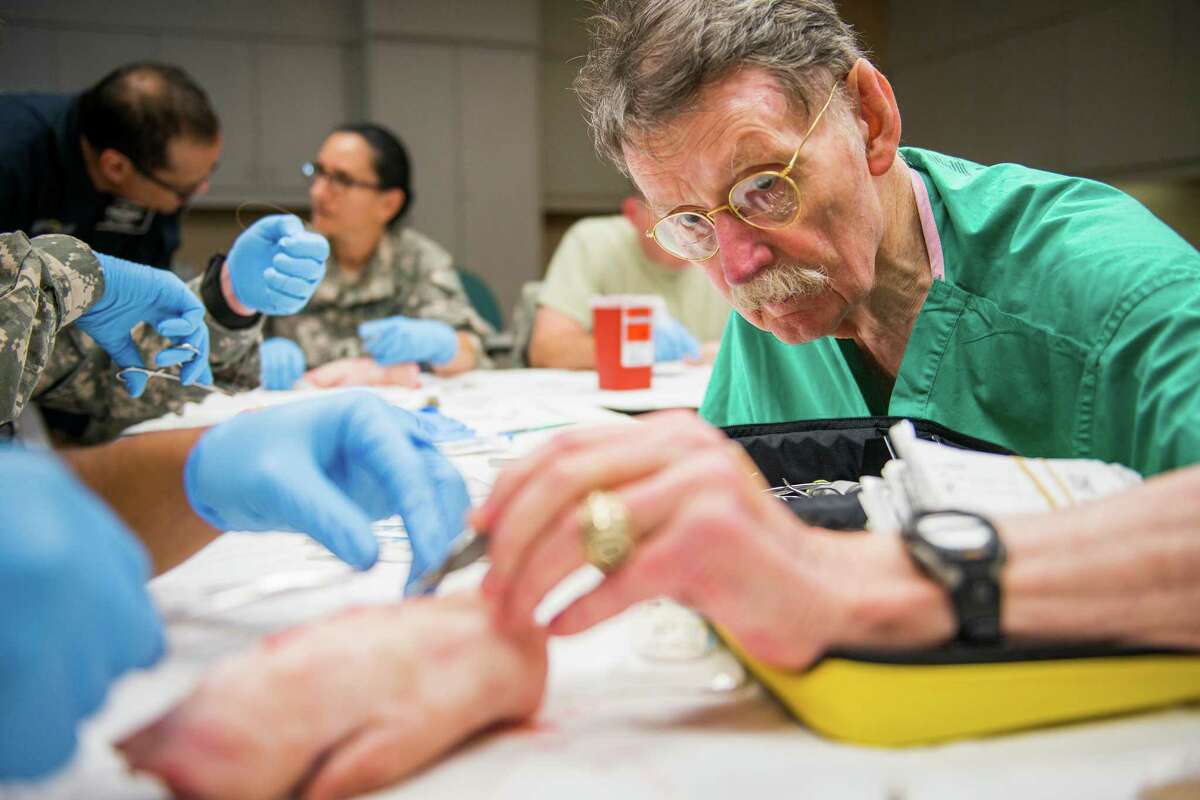 Dr. James "Red" Duke instructs a group of U.S. Army flight medics in suturing techniques.