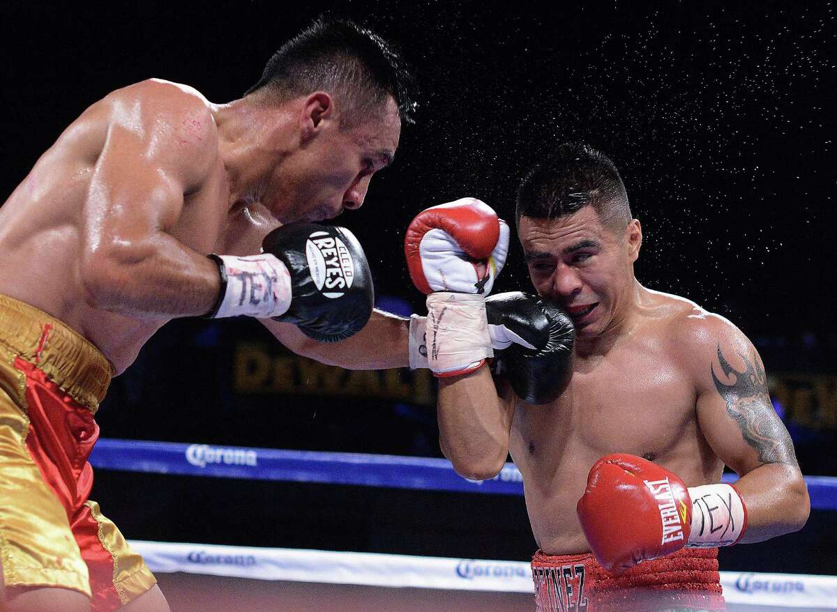 Daniel Quevedo, right, lands a left on Raul Martinez during the Golden Boy Live! boxing card at Cowboys Dance Hall on Monday, Sept. 2, 2013.