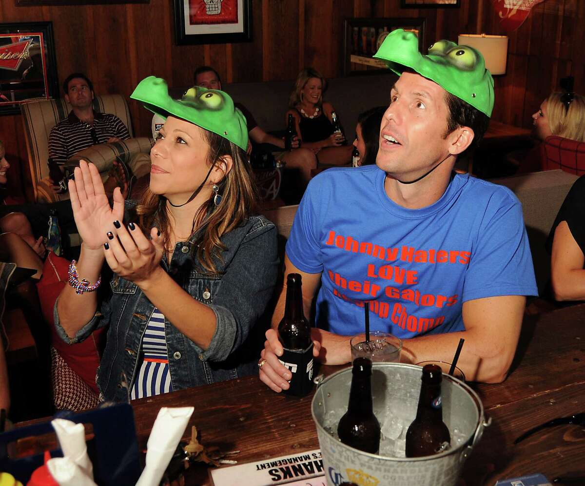 Florida Gator fan Caryn Botknecht and Aggie fan John Reilly, who lost a bet, watch the Florida football game at Luke's Icehouse on Durham Saturday August 31, 2013.(Dave Rossman photo)