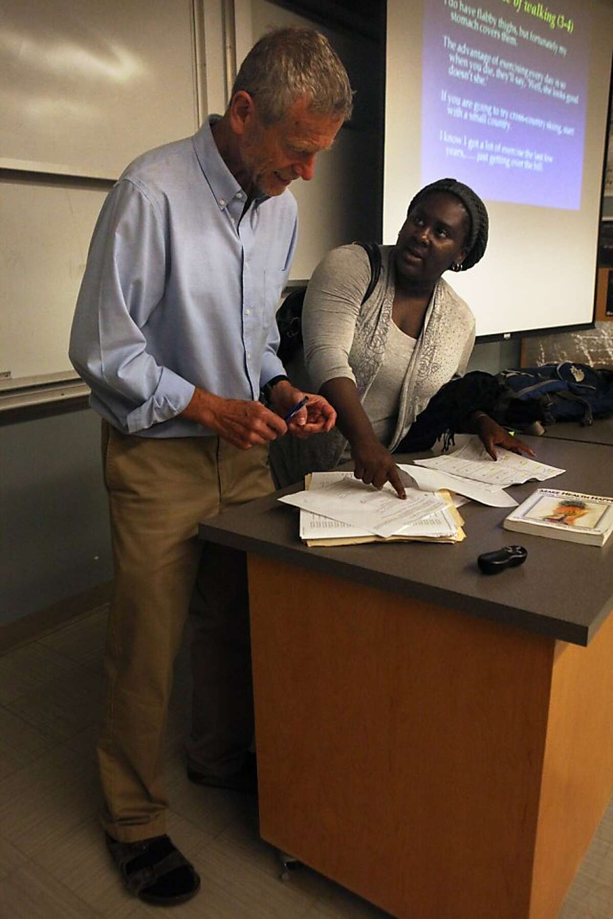 Student Chioma Ureh (right) talks with professor Erik Peper (left) after a class called Holistic Health 380: Western Perspectives at San Francisco State University in California on Monday, August 26, 2013.
